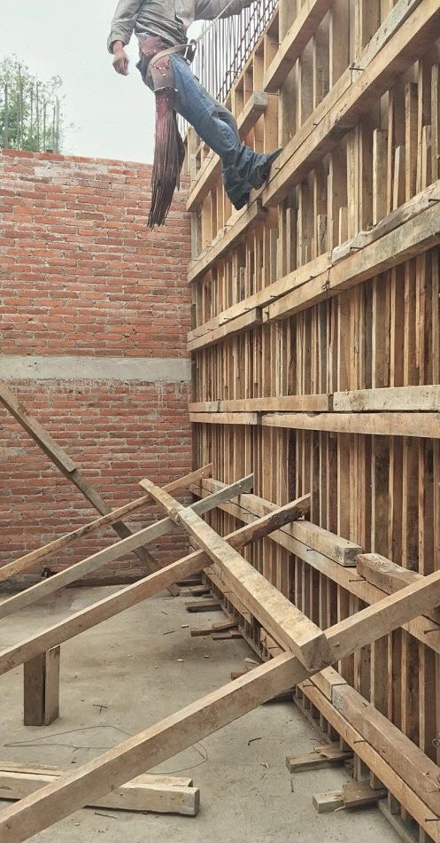Carpenter on Heavy Pinewood Waler Wall Formwork and Diagonal Shoring
